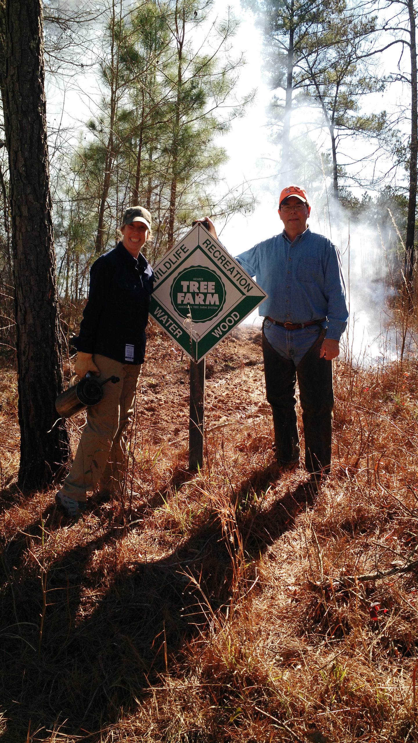 My uncle, Chuck Williams (R) and me (L) standing next to his American Tree Farm sign. Photo by Beth Williams