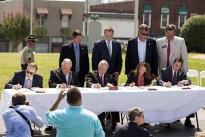 Officials gather to sign a Memorandum of Agreement establishing the Appalachian Regional Port, Tuesday, July 28, 2015, in Chatsworth, Ga. From left, CSX Executive Vice President Clarence Gooden, Georgia Speaker of the House David Ralston, Georgia Gov. Nathan Deal, Murray County Commissioner Brittany Pittman, and Georgia Ports Authority Executive Director Curtis Foltz.